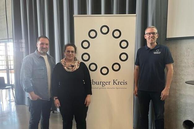 Drei Personen stehen vor einem Banner des &bdquo;B&uuml;rger Kreis&ldquo; in einem modernen Veranstaltungsraum.