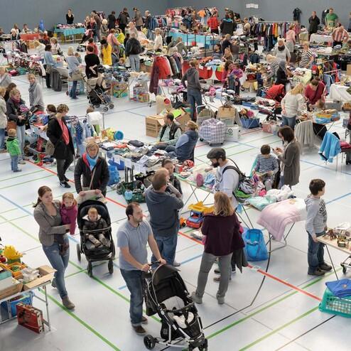 Gro&szlig;er Flohmarkt in einer Halle mit vielen St&auml;nden, Besuchern und einer Vielzahl an angebotenen Gegenst&auml;nden.