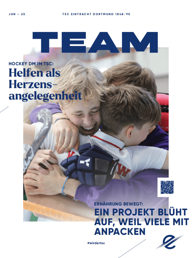 Junge Sportler umarmen sich freudig nach einem Hockeyspiel, im Hintergrund eine Sporthalle mit Teamfarben.
