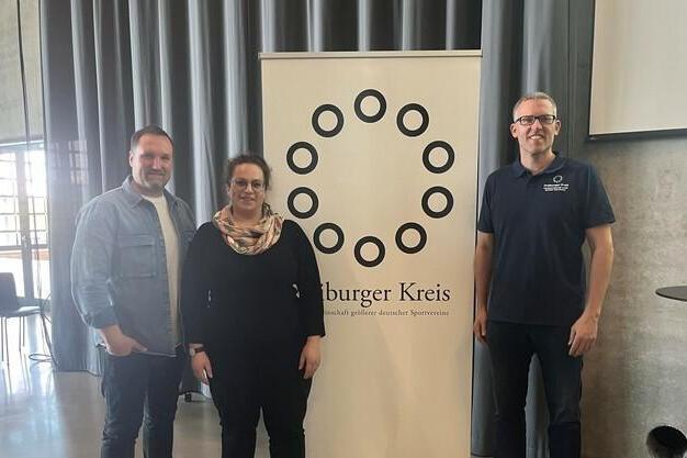 Drei Personen stehen vor einem Banner des &bdquo;B&uuml;rger Kreis&ldquo; in einem modernen Veranstaltungsraum.