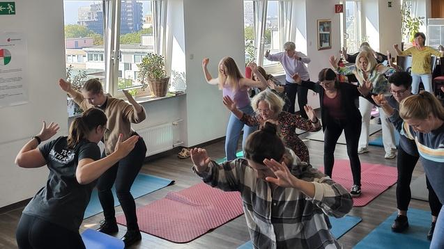 Gruppen Fitness Gruppe von Menschen in einem Raum, die auf Übungsmatten gemeinsam Fitnessübungen ausführen.