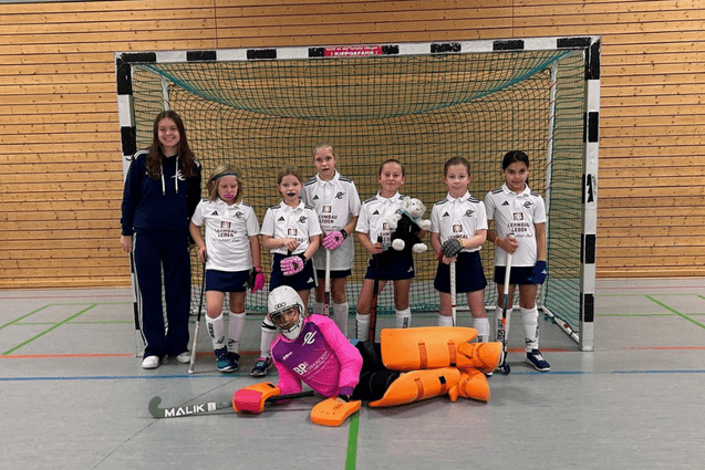 Sechs Kinder sitzen auf einer Mauer mit herbstlicher Landschaft im Hintergrund; darunter stehen Sportlerinnen in einer Halle vor einem Tor.