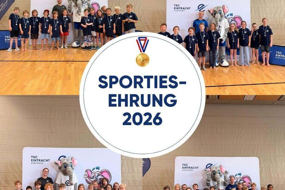 Gruppenfoto von Kindern mit Medaillen bei der Sportehrenveranstaltung 2026, mit Maskottchen im Hintergrund.