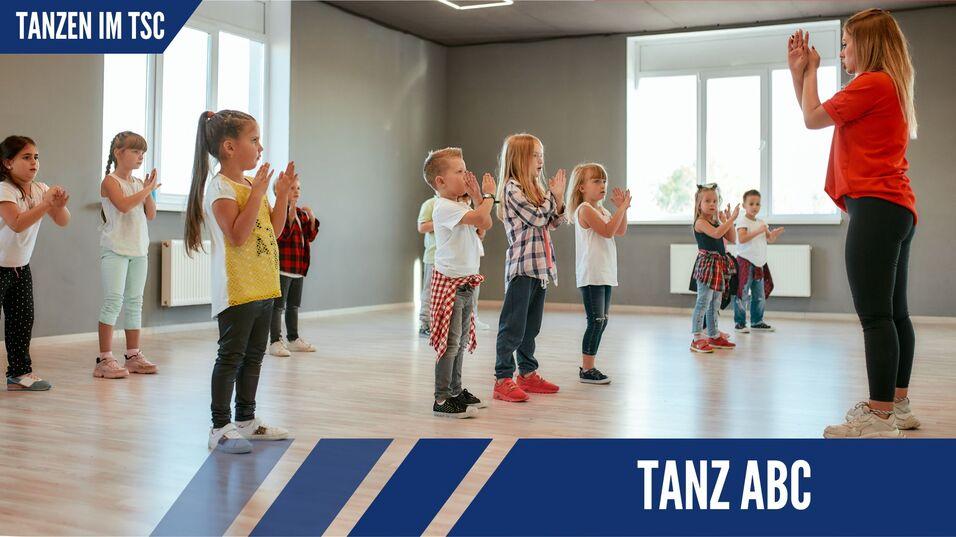 Gruppe von Kindern in Tanzkleidung im Klassenraum, die mit einer Lehrerin synchron klatschen.