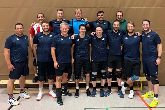 BFS Herren I Gruppe von zehn männlichen Volleyballspielern in Sportkleidung, lächelnd und poses auf einem Hallenboden.