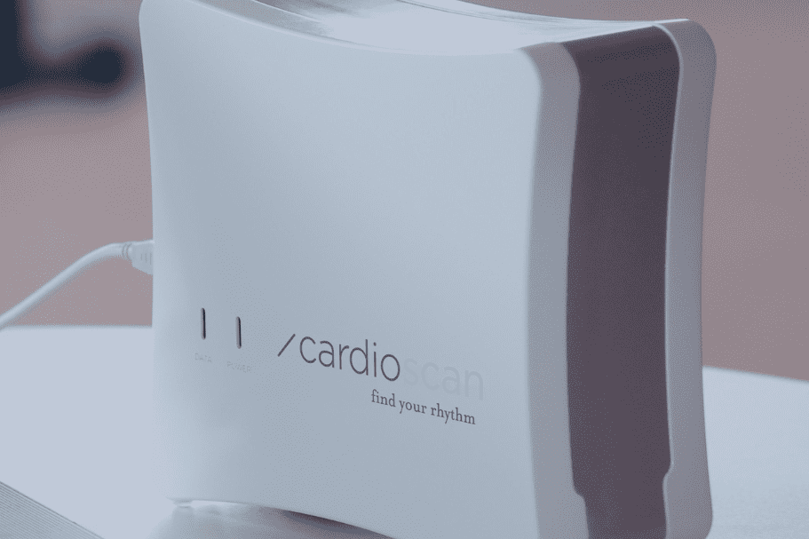 Ger&auml;t zur Stressmessung namens CardioScan neben einem Laptop, mit einem Hinweistext &uuml;ber Stressbewertung im Hintergrund.