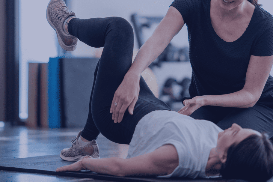 Trainingssituation mit einer Trainerin, die einer &Uuml;benden bei Beckenboden&uuml;bungen Anleitungen gibt.