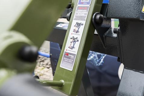Nahaufnahme eines Bedienfelds an einem Fitnessger&auml;t mit Hinweisetikett und Anleitung in gr&uuml;ner Farbe.