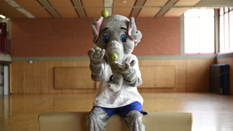 Maskottchen Victor jongliert mit Obst