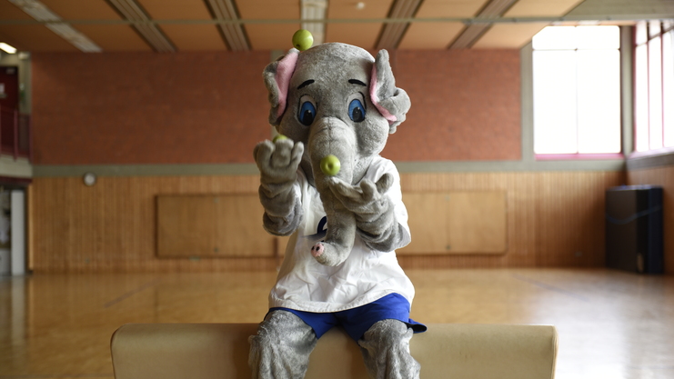 Maskottchen Victor jongliert mit Obst